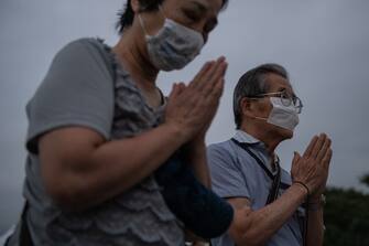 1227930043 HIROSHIMA, JAPAN - AUGUST 06: People pray in remembrance during the 75th anniversary of the Hiroshima atomic bombing, on August 6, 2020 in Hiroshima, Japan. In a ceremony that has been scaled back significantly because of Covid-19 coronavirus, Japan will mark the 75th anniversary of the first atomic bomb that was dropped by the United States on Hiroshima on August 6, 1945. The bomb instantly killed an estimated 70,000 people and thousands more in coming years from radiation effects. Three days later the United States dropped a second atomic bomb on Nagasaki which ended World War II. (Photo by Carl Court/Getty Images)