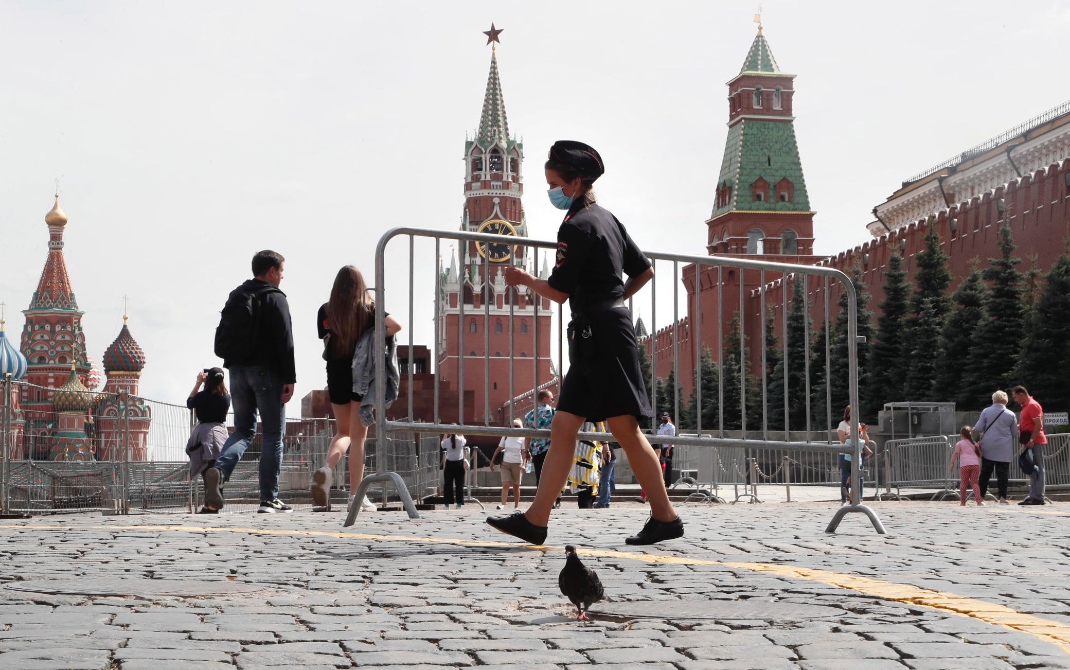 RUSSIA PANDEMIC CORONAVIRUS COVID19 epa08583404 A female police officer wearing a protective face mask moves a temporary fencing on the Red Square in Moscow, Russia, 04 August 2020. Russian authorities continue to gradually ease restrictions imposed to prevent the spread of the pandemic COVID-19 disease caused by the SARS-CoV-2 coronavirus in the country. EPA/MAXIM SHIPENKOV