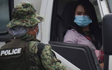 A police officer (L) speaks to a motorist at a checkpoint as they conduct identity checks during a new round of lockdown measures for the COVID-19 coronavirus outbreak, along a road in Manila on August 4, 2020. - Millions of people in the Philippines went back into lockdown on August 4 as global coronavirus infections keep soaring, with the World Health Organisation warning against relying on a vaccine "silver bullet" to end the pandemic. (Photo by Ted ALJIBE / AFP) (Photo by TED ALJIBE/AFP via Getty Images)