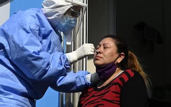 A doctor takes samples for a PCR test to a woman whit COVID-19 symptoms at the mobile health unit in Villa Fiorito, Buenos Aires outskirts, Argentina, on August 3, 2020 amid the COVID-19 pandemic. - Villa Fiorito has some 43,000 inhabitants and is hometown of former footballer Diego Maradona. Argentina surpassed 200,000 cases of Covid-19 on the eve, the Ministry of Health reported, and announced the ban on social gatherings throughout the country starting today. (Photo by JUAN MABROMATA / AFP) (Photo by JUAN MABROMATA/AFP via Getty Images)