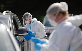 epa08587182 Health workers perform swab tests at a drive-thru COVID-19 testing lab in Namur, Belgium 06 August 2020. After a sharp decline in coronavirus infections, Belgium has witnessed a surge in COVID-19 cases over the past weeks. Testing is now mandatory for people traveling back from what the government labeled as red regions abroad and highly recommended for those coming from orange regions.  EPA/OLIVIER HOSLET