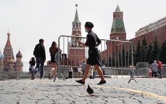 epa08583404 A female police officer wearing a protective face mask moves a temporary fencing on the Red Square in Moscow, Russia, 04 August 2020. Russian authorities continue to gradually ease restrictions imposed to prevent the spread of the pandemic COVID-19 disease caused by the SARS-CoV-2 coronavirus in the country.  EPA/MAXIM SHIPENKOV