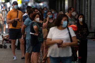 People wearing face masks queue to buy lottery tickets in the centre of Madrid on July 29, 2020. - Madrid moved to make mask-wearing obligatory at all times in public as Spain grappled with the fallout from a spike in virus cases that has triggered several international travel warnings. (Photo by PIERRE-PHILIPPE MARCOU / AFP) (Photo by PIERRE-PHILIPPE MARCOU/AFP via Getty Images)