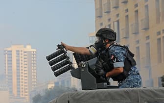 1227962535 A member of the Lebanese security forces loads tear gas into a launcher during clashes in downtown Beirut on October8, 2020, following a demonstration against a political leadership they blame for a monster explosion that killed more than 150 people and disfigured the capital Beirut. (Photo by Anwar AMRO / AFP) (Photo by ANWAR AMRO/AFP via Getty Images)