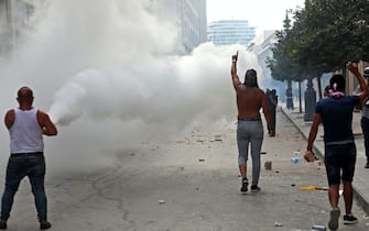 1227962714 Lebanese protesters gesture towards security forces during clashes in downtown Beirut on October8, 2020, following a demonstration against a political leadership they blame for a monster explosion that killed more than 150 people and disfigured the capital Beirut. (Photo by Anwar AMRO / AFP) (Photo by ANWAR AMRO/AFP via Getty Images)