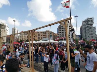 epa08591871 Lebanese people stand around mock gallows erected during a protest in the aftermath of explosion, in Beirut, Lebanon, 08 August 2020. People gathered for the so-called 'the Saturday of the hanging ropes' to protest against the political leaders and calling on those responsible over the explosion to be held accountable. Lebanese Health Ministry on 07 August said at least 154 people were killed, and more than 5,000 injured in the Beirut blast that devastated the port area on 04 August and believed to have been caused by an estimated 2,750 tons of ammonium nitrate stored in a warehouse.  EPA/Nabil Mounzer