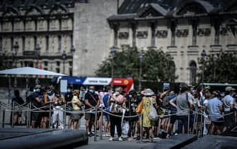 People wearing a protective face mask queue for the Louvre museum, in Paris on August 6, 2020. (Photo by STEPHANE DE SAKUTIN / AFP) (Photo by STEPHANE DE SAKUTIN/AFP via Getty Images)