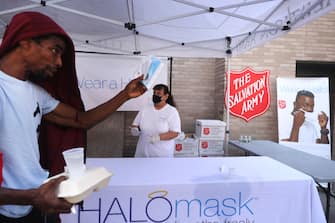 1265058658 NEW YORK, NEW YORK - AUGUST 10: People receive free face masks at a Salvation Army Community Center on August 10, 2020 in New York City. The masks, which are washable and were donated by the company HALO, were given out to individuals during the daily free lunch at the center. Currently, The United States has now surpassed 5 million confirmed cases of Covid-19 as of Sunday. (Photo by Spencer Platt/Getty Images)