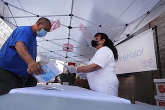 NEW YORK, NEW YORK - AUGUST 10: People receive free face masks at a Salvation Army Community Center  on August 10, 2020 in New York City. The masks, which are washable and were donated by the company HALO, were given out to individuals during the daily free lunch at the center. Currently, The United States has now surpassed 5 million confirmed cases of Covid-19 as of Sunday.  (Photo by Spencer Platt/Getty Images)