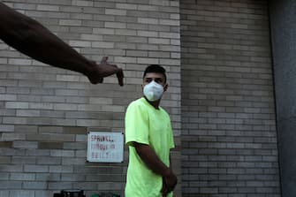 1265058704 NEW YORK, NEW YORK - AUGUST 10: People wait in line for lunch and a free face mask at a Salvation Army Community Center on August 10, 2020 in New York City. The masks, which are washable and were donated by the company HALO, were given out to individuals during the daily free lunch at the center. Currently, The United States has now surpassed 5 million confirmed cases of Covid-19 as of Sunday. (Photo by Spencer Platt/Getty Images)
