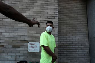 NEW YORK, NEW YORK - AUGUST 10: People wait in line for lunch and a free face mask at a Salvation Army Community Center  on August 10, 2020 in New York City. The masks, which are washable and were donated by the company HALO, were given out to individuals during the daily free lunch at the center. Currently, The United States has now surpassed 5 million confirmed cases of Covid-19 as of Sunday.  (Photo by Spencer Platt/Getty Images)