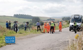 Network Rail engineers walk past members of the media  near the scene of a train crash by Stonehaven in northeast Scotland on August 12, 2020. - A passenger train derailed in northeast Scotland on Wednesday, with reports of "serious injuries" in what First Minister Nicola Sturgeon described as "an extremely serious incident". (Photo by Michal Wachucik / AFP) (Photo by MICHAL WACHUCIK/AFP via Getty Images)