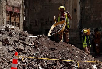 epa08599480 Yemenis work on the site of rain-collapsed buildings in the old city of Sana a, Yemen, 12 August 2020. According to reports, torrential rains and flooding in Yemen have claimed the lives of at least 170 people, including 19 children, and destroyed hundreds of houses and roads across the war-torn Arab country over the past few weeks.  EPA/YAHYA ARHAB