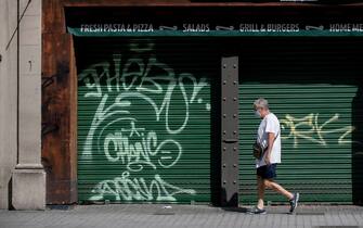 A man walk past a closed restaurant that is up for rent in central Barcelona on August 12, 2020. - In Spain, the coronavirus has pushed small businesses to the brink of collapse. So far, 40,000 bars, restaurants and hotels have permanently closed, with the figure seen rising to 65,000 by the end of the year -- or 20 percent of the total, Spain's hostelry federation says. (Photo by Josep LAGO / AFP) (Photo by JOSEP LAGO/AFP via Getty Images)