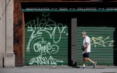 A man walk past a closed restaurant that is up for rent in central Barcelona on August 12, 2020. - In Spain, the coronavirus has pushed small businesses to the brink of collapse. So far, 40,000 bars, restaurants and hotels have permanently closed, with the figure seen rising to 65,000 by the end of the year -- or 20 percent of the total, Spain's hostelry federation says. (Photo by Josep LAGO / AFP) (Photo by JOSEP LAGO/AFP via Getty Images)