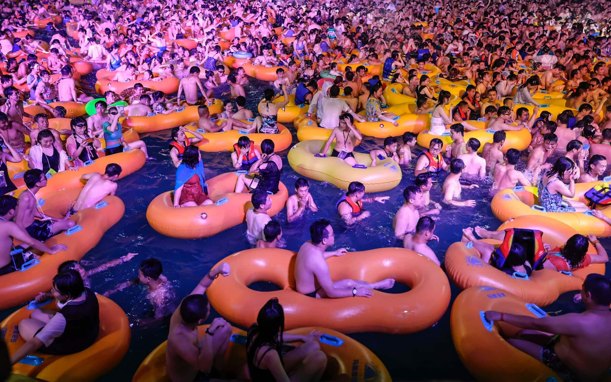 TOPSHOT - This photo taken on August 15, 2020 shows people watching a performance as they cool off in a swimming pool in Wuhan in China's central Hubei province. (Photo by STR / AFP) / China OUT (Photo by STR/AFP via Getty Images)