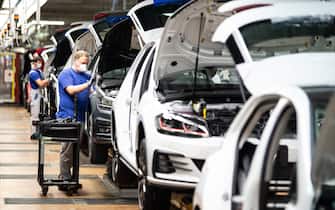 Employees of German car maker Volkswagen (VW) work at the assembly line of the company's plant in Wolfsburg, northern Germany, after production at the plant restarted on April 27, 2020, amid the new coronavirus COVID-19 pandemic. (Photo by Swen Pförtner / POOL / AFP) (Photo by SWEN PFORTNER/POOL/AFP via Getty Images)