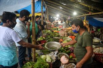 Customers buy vegetables in Siliguri on August 19, 2020, as a state-imposed lockdown will be held on August 20 and 21 against the surge in COVID-19 coronavirus cases. (Photo by DIPTENDU DUTTA / AFP) (Photo by DIPTENDU DUTTA/AFP via Getty Images)