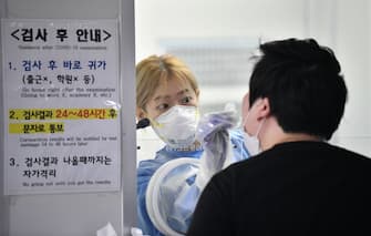 A medical staff in a booth takes test samples for the COVID-19 coronavirus from a visitor at a coronavirus testing station in Seoul on August 18, 2020. - South Korea on August 18 ordered nightclubs, museums and buffet restaurants closed and banned large-scale gatherings in and around the capital as a burst of new coronavirus cases sparked fears of a major second wave. (Photo by Jung Yeon-je / AFP) (Photo by JUNG YEON-JE/AFP via Getty Images)