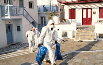 MYKONOS, GREECE - MAY 25: Contractors dressed in personal protective equipment (P.P.E.) remove debris from a home in the Little Venice neighborhood on May 25, 2020 in Mykonos, Greece. After months of being on lockdown due to the coronavirus, Greece will begin to ease travel restrictions on movement between the mainland and the countrys islands. (Photo by Byron Smith/Getty Images)