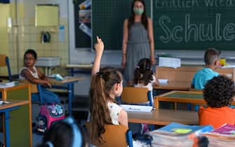 A student raises her hand in a classroom at the Petri primary school in Dortmund, western Germany, on August 12, 2020, amid the novel coronavirus COVID-19 pandemic. - Schools in the western federal state of North Rhine-Westphalia re-started under strict health guidelines after the summer holidays. (Photo by Ina FASSBENDER / AFP) (Photo by INA FASSBENDER/AFP via Getty Images)