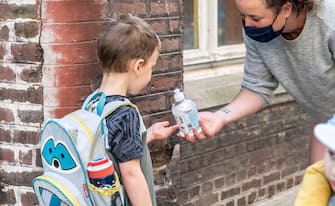 Illustration picture shows a teacher giving desinfecting gel to a pupil at the entrance of De Kleine Icarus school in Gent, Tuesday 02 June 2020. Schools for children under six years old are reopening today for everyone. Belgium is in its twelfth week of confinement in the ongoing corona virus crisis and the third week of the phase 2 of the deconfinement. 
BELGA PHOTO JONAS D'HOLLANDER (Photo by JONAS D'HOLLANDER/BELGA MAG/AFP via Getty Images)