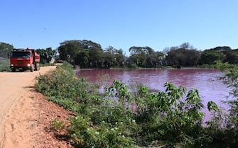 A truck drives by the Lago Cerro, coloured by alleged chemical disposals from a tannery located on its banks, in Limpio, 25 km northeast of Asuncion, Paraguay, on August 6, 2020. - According to experts from the National University Multidisciplinary Lab, the colour of the water is due to the presence of heavy metals like iron, chromium, and zinc, among others, commonly used in the tanning process. (Photo by NORBERTO DUARTE / AFP) (Photo by NORBERTO DUARTE/AFP via Getty Images)