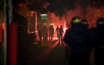 French anti-riot policemen escort Paris Saint-Germain (PSG) supporters around the Parc des Princes stadium on August 23, 2020, after the UEFA Champions League final football match between PSG and Bayern Munich played at the Luz stadium in Lisbon. (Photo by Alain JOCARD / AFP) (Photo by ALAIN JOCARD/AFP via Getty Images)