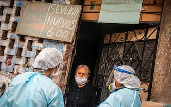Peruvian Health Ministry personnel examine and carry out tests to discard COVID-19 in patients over 60 years old at their houses in Perales neighbourhood, Santa Anita district, east of Lima on August 20, 2020. - As COVID-19 cases pass 550.000 in Peru, health care personnel pay door to door health checks in the residential area of Perales, Lima, under military and police supervision (Photo by Ernesto BENAVIDES / AFP) (Photo by ERNESTO BENAVIDES/AFP via Getty Images)