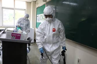 SEOUL, SOUTH KOREA - MAY 11: Disinfection professionals wearing protective clothing spray anti-septic solution at classroom to prevent the spread of the coronavirus (COVID-19) ahead of school re-opening on May 11, 2020 in Seoul, South Korea. South Korea's education ministry announced plans to re-open schools starting from May 13, more than two months after schools were closed in a precautionary measure against the coronavirus. Coronavirus cases linked to clubs and bars in Seoul's multicultural district of Itaewon have jumped to 54, an official said Sunday, as South Korea struggles to stop the cluster infection from spreading further. According to the Korea Center for Disease Control and Prevention, 35 new cases were reported. The total number of infections in the nation tallies at 10,909. (Photo by Chung Sung-Jun/Getty Images)