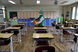 SEOUL, SOUTH KOREA - MAY 19: A disinfection worker sprays anti-septic solution at classroom to prevent the spread of the coronavirus (COVID-19) ahead of school re-opening at Yeouido girl's high school on May 19, 2020 in Seoul, South Korea. Senior high school students are able to return to school from tomorrow, as South Koreans take measures to protect themselves against the spread of coronavirus. South Korea's education ministry announced plans to re-open schools starting for senior high school students, more than two months after schools were closed in a precautionary measure against the coronavirus. According to the Korea Center for Disease Control and Prevention, 13 new cases were reported. The total number of infections in the nation tallies at 11,078. (Photo by Chung Sung-Jun/Getty Images)