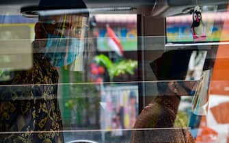 Bus crew members wear face shields as a preventive measure to curb the spread of the COVID-19 coronavirus on a bus in Banda Aceh on August 22, 2020. (Photo by CHAIDEER MAHYUDDIN / AFP) (Photo by CHAIDEER MAHYUDDIN/AFP via Getty Images)