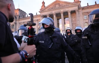 BERLIN, GERMANY - AUGUST 29: German riot police stand guard outside the Reichstag during protests against coronavirus-related restrictions and government policy on August 29, 2020 in Berlin, Germany. City authorities had banned the planned protest, citing the flouting of social distancing by participants in a similar march that drew at least 17,000 people a few weeks ago, but a court overturned the ban. (Photo by Omer Messinger/Getty Images)