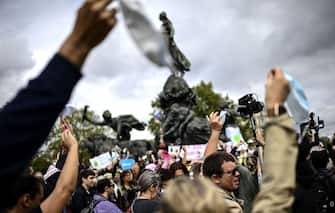Protesters hold up face masks  during a protest against the mandatory wearing of face masks on the Place de La Nation in Paris on August 29, 2020, amid the Covid-19 (novel coronavirus) pandemic. - Masks, which were already compulsory on public transport, in enclosed public spaces, and outdoors in Paris in certain high-congestion areas around tourist sites, were made mandatory outdoors citywide on August 28 to fight the rising coronavirus infections. (Photo by Christophe ARCHAMBAULT / AFP) (Photo by CHRISTOPHE ARCHAMBAULT/AFP via Getty Images)