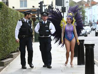 Police officers on patrol engage in conversation with pilates instructor Juliana Campos as she poses in her carnival costume in Notting Hill, London, on what would have been the weekend of the Notting Hill Carnival, after the 2020 carnival was cancelled due to the coronavirus pandemic, with events being streamed online. (Yui Mok / IPA/Fotogramma, London - 2020-08-30) p.s. la foto e' utilizzabile nel rispetto del contesto in cui e' stata scattata, e senza intento diffamatorio del decoro delle persone rappresentate