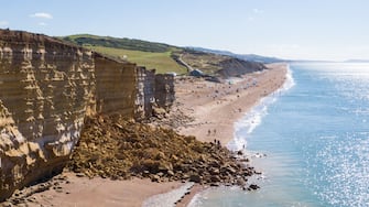 BURTON BRADSTOCK, DORSET - AUGUST 30: Aerial view of the 9,000 ton cliff fall on August 30, 2020 in Burton Bradstock, Dorset. The fall happened at Hive Beach near the village of Burton Bradstock, Dorset Council said. Fire crews using thermal imaging equipment were called in to check for any trapped casualties but nothing was found. The council described it as a "huge" rock fall and said recent heavy rain had made cliffs unstable. (Photo by Finnbarr Webster/Getty Images)