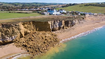 BURTON BRADSTOCK, DORSET - AUGUST 30: Aerial view of the 9,000 ton cliff fall on August 30, 2020 in Burton Bradstock, Dorset. The fall happened at Hive Beach near the village of Burton Bradstock, Dorset Council said. Fire crews using thermal imaging equipment were called in to check for any trapped casualties but nothing was found. The council described it as a "huge" rock fall and said recent heavy rain had made cliffs unstable. (Photo by Finnbarr Webster/Getty Images)