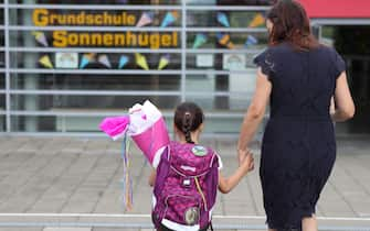 OBERPLEIS, GERMANY - AUGUST 13: First graders arrive with goodie bags for their first introductory day to school during the coronavirus pandemic on August 13, 2020 in Oberpleis near Bonn, Germany. Classes at schools across Germany are beginning this month with face mask requirements varying by state. Coronavirus infection rates are climbing again in Germany, from an average of 400 new cases per day about two weeks ago up to over 1,300 in recent days, according to the Robert Koch Institute. (Photo by Andreas Rentz/Getty Images)