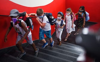 1228010741 TOPSHOT - Students with face masks go upstairs to their classrooms at the Petri primary school in Dortmund, western Germany, on August 12, 2020, amid the novel coronavirus COVID-19 pandemic. - Schools in the western federal state of North Rhine-Westphalia re-started under strict health guidelines after the summer holidays. (Photo by Ina FASSBENDER / AFP) (Photo by INA FASSBENDER/AFP via Getty Images)