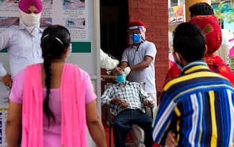 Health officials collect a nasal swab sample from a man to test for the Covid-19 coronavirus, at a hospital in Amritsar on September 2, 2020. (Photo by NARINDER NANU / AFP) (Photo by NARINDER NANU/AFP via Getty Images)
