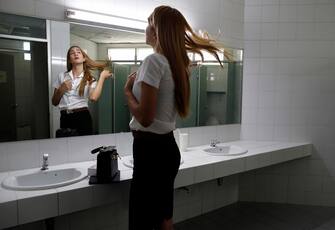 epa08645098 A Thai transgender student Siwakorn Thatsanasorn wearing female university student uniform flips her hair in a female toilet at Thammasat University Rangsit Campus in Pathum Thani province, Thailand, 24 August 2020 (issued 04 September 2020). Outdated regulations at most schools and universities in Thailand mean many transgender people are forced to wear a uniform in class that does not match their gender identity. Since June, Thammasat University has removed those regulations, allowing 20 year-old Siwakorn 'Buzzy' Thatsanasorn to wear the outfit of her choice at school. But Siwakorn says that transgenders in primary and secondary schools are still not allowed to choose gender-appropriate school uniforms.  EPA/RUNGROJ YONGRIT  ATTENTION: This Image is part of a PHOTO SET