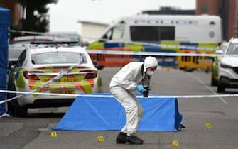 A police forensics officer gathers evidence near to forensics tents and evidence markers inside a cordon on Irving Street, following a major stabbing incident in the centre of Birmingham, central England, on September 6, 2020. - British police declared a "major incident" early on September 6 after multiple people were stabbed in the centre of England's second city Birmingham. Violence broke out at about 12:30 am (2330 GMT Saturday) in and around the Arcadian Centre, a popular venue filled with restaurants, nightclubs and bars. (Photo by Oli SCARFF / AFP) (Photo by OLI SCARFF/AFP via Getty Images)