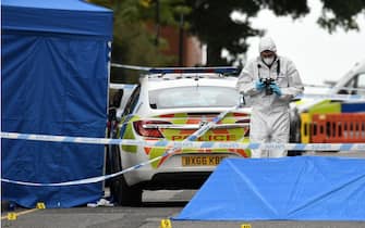A police forensics officer gathers evidence near to forensics tents and evidence markers inside a cordon on Irving Street, following a major stabbing incident in the centre of Birmingham, central England, on September 6, 2020. - British police declared a "major incident" early on September 6 after multiple people were stabbed in the centre of England's second city Birmingham. Violence broke out at about 12:30 am (2330 GMT Saturday) in and around the Arcadian Centre, a popular venue filled with restaurants, nightclubs and bars. (Photo by Oli SCARFF / AFP) (Photo by OLI SCARFF/AFP via Getty Images)