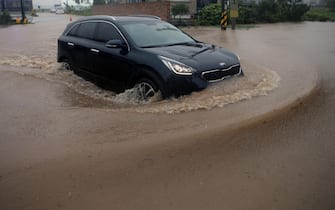 epa08651804 A car drives on a flooded road following heavy rain caused by the powerful Typhoon Haishen in Gangneung, South Korea, 07 September 2020.  EPA/YONHAP SOUTH KOREA OUT