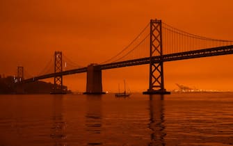 SAN FRANCISCO, CA - SEPTEMBER 09: A ship passes beneath the Bay Bridge as smoke from various wildfires burning across Northern California mixes with the marine layer, blanketing San Francisco in darkness and an orange glow on September 9, 2020 in San Francisco, California. Over 2 million acres have burned this year as wildfires continue to burn across the state. (Photo by Philip Pacheco/Getty Images)