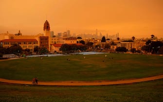 People relax under an orange smoke-filled sky at Dolores Park in San Francisco, California on September 9, 2020. - More than 300,000 acres are burning across the northwestern state including 35 major wildfires, with at least five towns "substantially destroyed" and mass evacuations taking place. (Photo by Brittany Hosea-Small / AFP) (Photo by BRITTANY HOSEA-SMALL/AFP via Getty Images)