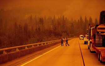 Law enforcement and fire personnel wait on the Enterprise Bridge to enter an area encroached by fire during the Bear fire, part of the North Lightning Complex fires, in unincorporated Butte County, in Oroville, California on September 9, 2020. - More than 300,000 acres are burning across the northwestern state including 35 major wildfires, with at least five towns "substantially destroyed" and mass evacuations taking place. (Photo by JOSH EDELSON / AFP) (Photo by JOSH EDELSON/AFP via Getty Images)