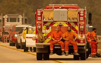 Inmate firefighters sit on the back of a fire truck on the Enterprise Bridge during the Bear fire, part of the North Lightning Complex fires, in unincorporated Butte County, in Oroville, California on September 9, 2020. - More than 300,000 acres are burning across the northwestern state including 35 major wildfires, with at least five towns "substantially destroyed" and mass evacuations taking place. (Photo by JOSH EDELSON / AFP) (Photo by JOSH EDELSON/AFP via Getty Images)