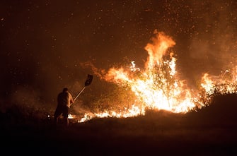 epa08667416 A firefighter works to extiguish a fire in Rairiz de Veiga, Ourense, Spain, 13 September 2020. According to reports, more than eleven forest fires in three regions have been buring, since 12 September.  EPA/Brais Lorenzo