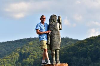 epa08671042 Unvailing of the statue from US First Lady Melania Trump by artists Bred Downey (unseen) and Ales 'Maxi' Zupevc (L) at her birthplace in Sevnica, Slovenia, 15 September 2020. The Old wooden statue of U.S. First Lady Melania Trump was burned on 4th July 2020.  EPA/IGOR KUPLJENIK